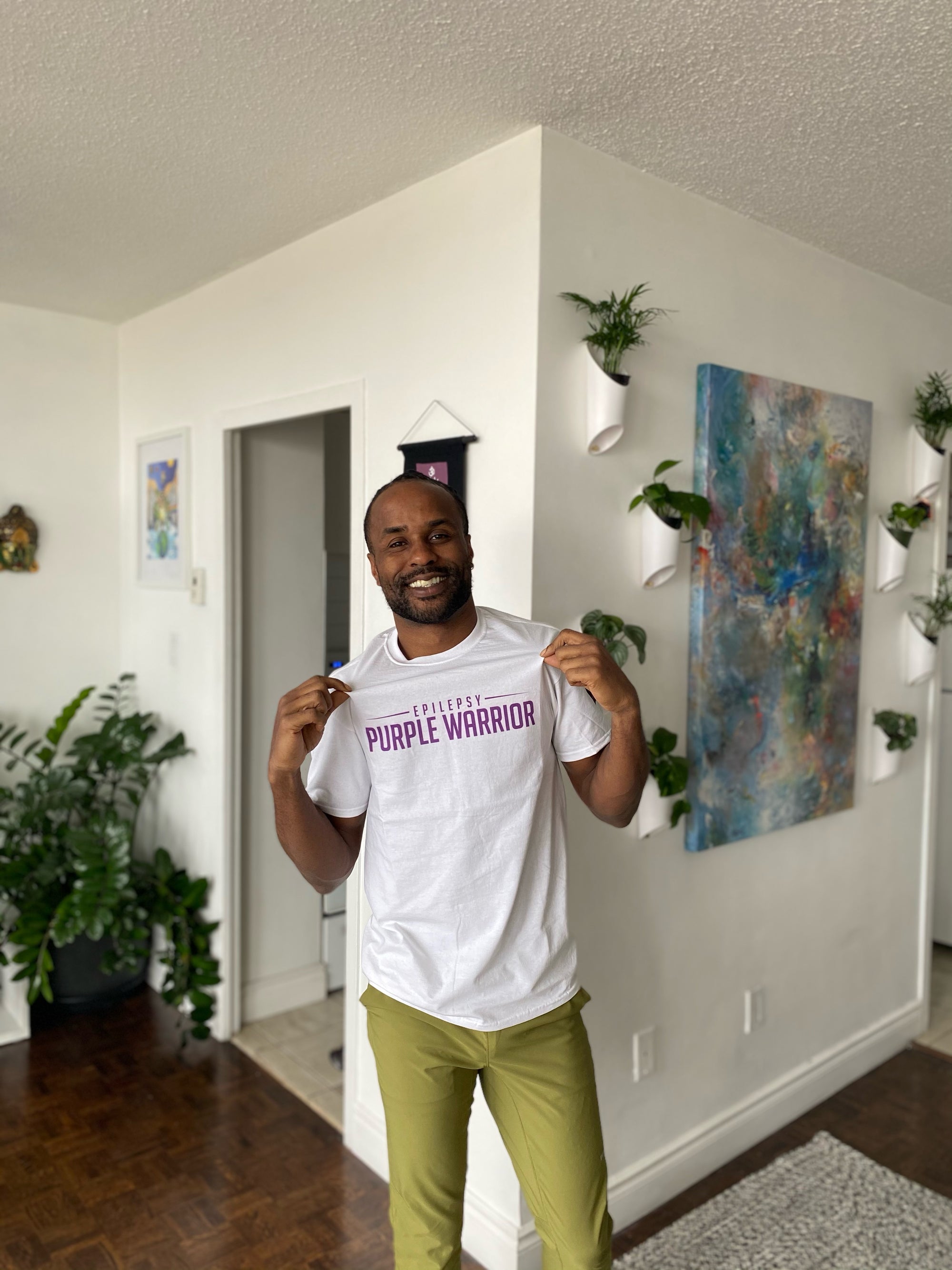 Akil Augustine wearing our Purple Warrior Unisex Shirt
